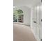 Bright bedroom featuring an arched window and closet with neutral carpet and paint at 11660 Windbrooke Way, Johns Creek, GA 30005