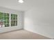Carpeted bedroom with a large window offering natural light and outdoor views at 11660 Windbrooke Way, Johns Creek, GA 30005