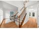 Bright foyer with hardwood floors, a staircase, and a view into a home office at 11660 Windbrooke Way, Johns Creek, GA 30005