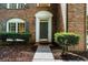 Close-up of the brick home's front entrance featuring manicured bushes and elegant window details at 11660 Windbrooke Way, Johns Creek, GA 30005