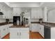 Bright kitchen with white cabinets, black appliances, and an island offering additional counter space at 11660 Windbrooke Way, Johns Creek, GA 30005