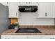 Modern kitchen with sleek black stovetop and white cabinetry at 11660 Windbrooke Way, Johns Creek, GA 30005