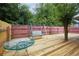 Relaxing backyard deck with a metal swing set and table, perfect for enjoying the outdoors under mature trees at 2468 Whistle Stop Dr, Norcross, GA 30071