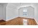 Empty bedroom features hardwood floors, white walls, natural light from a window, and vaulted ceilings at 2468 Whistle Stop Dr, Norcross, GA 30071