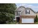 Charming two-story home features stone accents, a two-car garage, and a well-maintained front yard at 2468 Whistle Stop Dr, Norcross, GA 30071