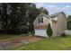 Side view of home showing gray siding, stone accents, landscaping, and driveway at 2468 Whistle Stop Dr, Norcross, GA 30071