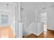 Upstairs hallway with wood floors and white walls showcasing natural light from a window on the left at 2468 Whistle Stop Dr, Norcross, GA 30071