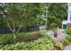 Lush landscaping with a variety of plants and a decorative fence creates a serene backyard garden area at 2468 Whistle Stop Dr, Norcross, GA 30071