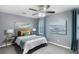 Bright bedroom featuring gray walls, carpet, a ceiling fan, and contemporary furniture with colorful pillows and accent art at 3568 Foxworth Ct, Buford, GA 30519