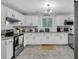 Bright kitchen with white cabinets, stainless steel appliances, and stone countertops at 3568 Foxworth Ct, Buford, GA 30519