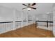 Large bonus room featuring hardwood floors, natural light, ceiling fan, and architectural columns at 5696 Kilrush Se Ct, Mableton, GA 30126