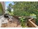 Wooden deck with white chairs, tables, grill, potted plants, and wooden railing at 2355 Ewing Ne Dr, Brookhaven, GA 30319