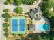 Aerial view of community pool, clubhouse, and tennis courts surrounded by lush trees at 3202 Lucky Pl, Conyers, GA 30013