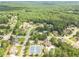 Aerial view of homes in a wooded community with tennis courts and a swimming pool at 3202 Lucky Pl, Conyers, GA 30013