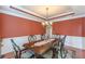 Formal dining room with a large wooden table, chandelier, and wainscoting detail at 3202 Lucky Pl, Conyers, GA 30013