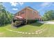 Exterior of a multi-story brick home with a deck overlooking a spacious green backyard at 3202 Lucky Pl, Conyers, GA 30013