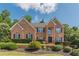Charming brick home with well-maintained landscaping, lush bushes, and manicured lawn at 3202 Lucky Pl, Conyers, GA 30013