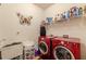 Laundry room with red washer and dryer, sink, and shelving for organized storage at 3202 Lucky Pl, Conyers, GA 30013