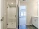 Bathroom featuring a white tiled shower with a glass door and sleek black tiled floors at 1979 Deco Dr, Kennesaw, GA 30144