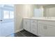 Modern bathroom featuring dual sinks, ample cabinet space, and sleek black flooring at 1979 Deco Dr, Kennesaw, GA 30144