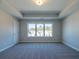 Spacious bedroom with plush carpet, tray ceiling, and large windows showcasing neighborhood views at 1979 Deco Dr, Kennesaw, GA 30144