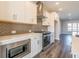 View of a kitchen with stainless steel appliances, gray backsplash, white counter tops, and modern light fixtures at 1979 Deco Dr, Kennesaw, GA 30144