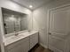 Bright bathroom features a double sink vanity with white cabinets and a large mirror at 2539 Brown Dove Way(Lot 81), Grayson, GA 30017