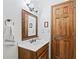 Traditional bathroom featuring a wood vanity with a white countertop, framed mirror, and wood door at 3355 Old Peachtree Rd, Dacula, GA 30019