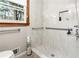 Accessible bathroom featuring grab bars and a tiled shower with built-in niche at 3355 Old Peachtree Rd, Dacula, GA 30019