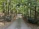 View of a long driveway with a stone and wooden fence leading to a home in a wooded area at 3355 Old Peachtree Rd, Dacula, GA 30019
