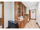 Hallway with wood-look floors and a built-in cabinet with glass doors at 3355 Old Peachtree Rd, Dacula, GA 30019
