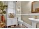 Charming powder room with pedestal sink, decorative mirror, and natural light at 561 Culberson Sw St, Atlanta, GA 30310