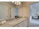 Bright bathroom featuring a double vanity with granite countertop and a large mirror at 1797 Kingsmere Run Dr, Loganville, GA 30052