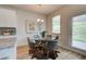 Sunlit dining area features a modern table and chairs next to a door with access to the backyard at 1797 Kingsmere Run Dr, Loganville, GA 30052