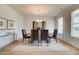 Elegant dining room featuring a modern chandelier, ample natural light, and seating for six at 1797 Kingsmere Run Dr, Loganville, GA 30052