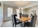 Elegant dining room featuring a modern chandelier, ample natural light, and seating for six at 1797 Kingsmere Run Dr, Loganville, GA 30052