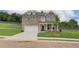 New two-story brick home with an attached two-car garage and a concrete driveway on a grass lot at 1797 Kingsmere Run Dr, Loganville, GA 30052