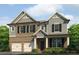 Charming two-story home with a brick and siding exterior, complemented by a well-manicured lawn and flowerbeds at 1797 Kingsmere Run Dr, Loganville, GA 30052