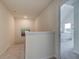 Upstairs hallway with neutral carpet, white walls, and view into primary bedroom at 1797 Kingsmere Run Dr, Loganville, GA 30052