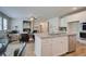 Spacious kitchen island with stainless steel appliances overlooks living area with fireplace and ceiling fan at 1797 Kingsmere Run Dr, Loganville, GA 30052