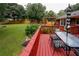 Backyard has a large red deck with table, chairs, and umbrella at 2202 Springdale Dr, Snellville, GA 30078