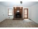 A cozy carpeted living room with a brick fireplace, natural light from the window, and a classic door at 2202 Springdale Dr, Snellville, GA 30078