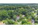 An aerial view of a property with lush green trees and a grey house with a well-manicured lawn at 1655 Oak Crest Ct, Marietta, GA 30066