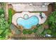 Aerial view of a kidney-shaped pool and spa with brick surround and patio at 1065 Beacon Hill Xing, Alpharetta, GA 30005
