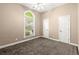 A carpeted bedroom features a bright window and two white doors, providing a simple and functional space at 1065 Beacon Hill Xing, Alpharetta, GA 30005