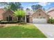 Attractive brick home with lush green lawn, tidy landscaping, and a convenient two-car garage at 1065 Beacon Hill Xing, Alpharetta, GA 30005