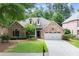 Charming single-story brick home with well-manicured lawn, two car garage, and inviting front porch at 1065 Beacon Hill Xing, Alpharetta, GA 30005