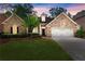 Charming brick home featuring a well-manicured lawn and a two-car garage in a desirable neighborhood at 1065 Beacon Hill Xing, Alpharetta, GA 30005