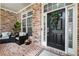 Welcoming brick porch featuring comfortable seating, decorative wreath, and charming front door at 1065 Beacon Hill Xing, Alpharetta, GA 30005
