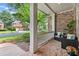 Inviting covered porch with brick flooring, comfortable seating, and a view of the landscaped front yard at 1065 Beacon Hill Xing, Alpharetta, GA 30005